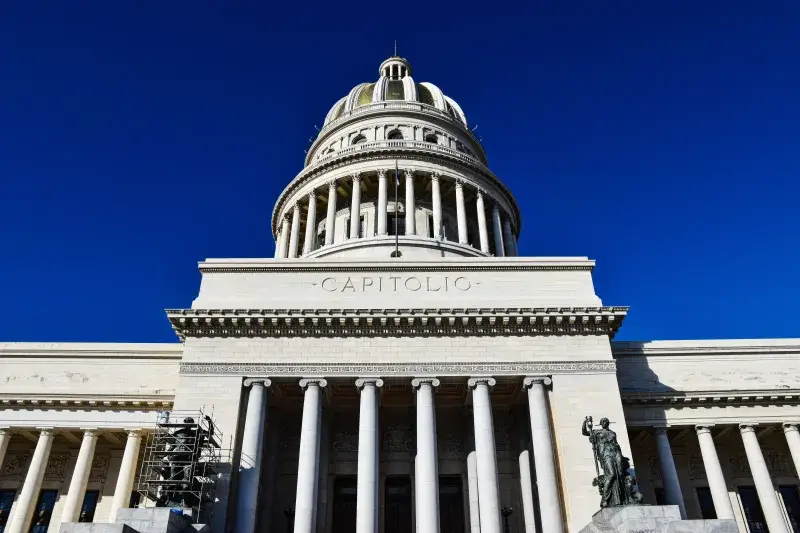 Low angle view of the iconic El Capitolio building under a clear blue sky in Havana, Cuba.