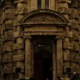 A classic architectural facade of a historic bank building with stone columns and arched entryway.