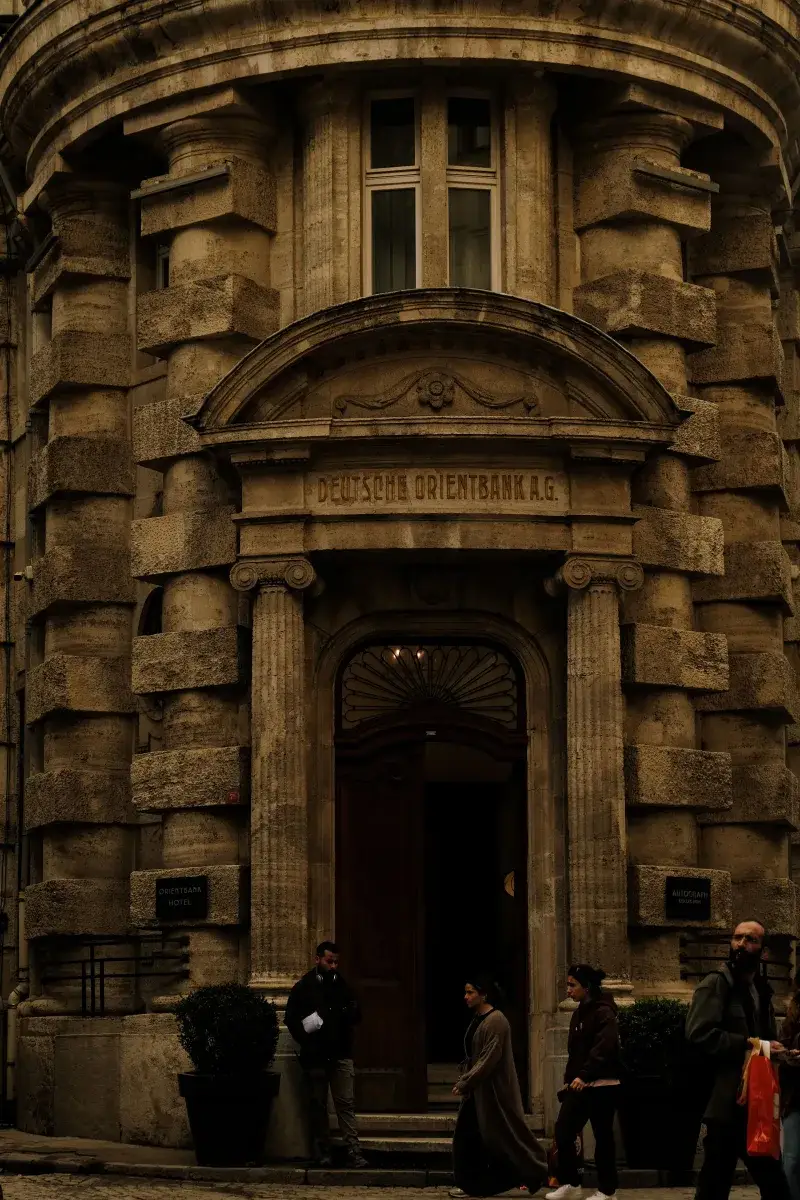 A classic architectural facade of a historic bank building with stone columns and arched entryway.