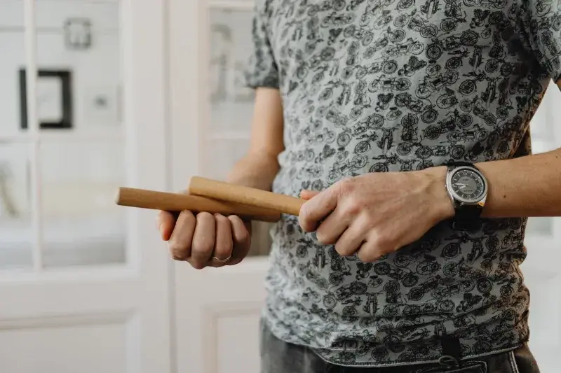 Detailed view of a person holding wooden claves, showcasing the instrument.