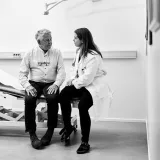 An older man talks with a female doctor