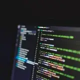 Programming code on a computer screen in a dark room, showcasing technology and IT expertise.