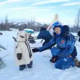 Family dressed in winter clothing, enjoying snow in Yamal-Nenets Autonomous Okrug, Russia.