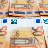 Detailed image of multiple 50 Euro bills stacked, showcasing currency design.