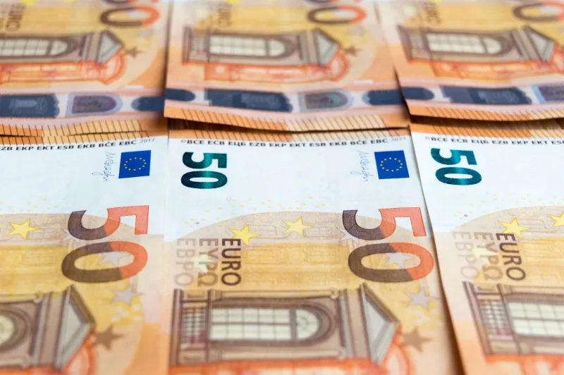 Detailed image of multiple 50 Euro bills stacked, showcasing currency design.
