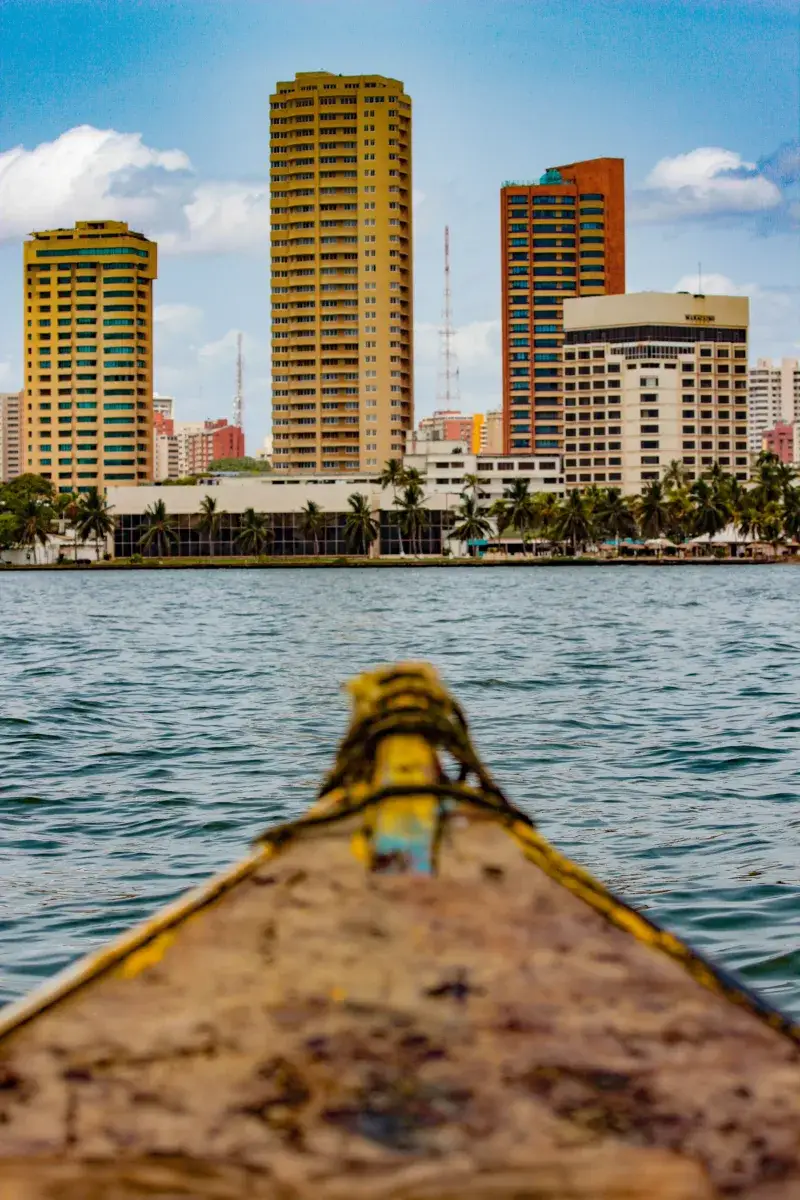 Scenic view of Maracaibo's skyline from a boat on the lake, showcasing tall buildings and a clear day.