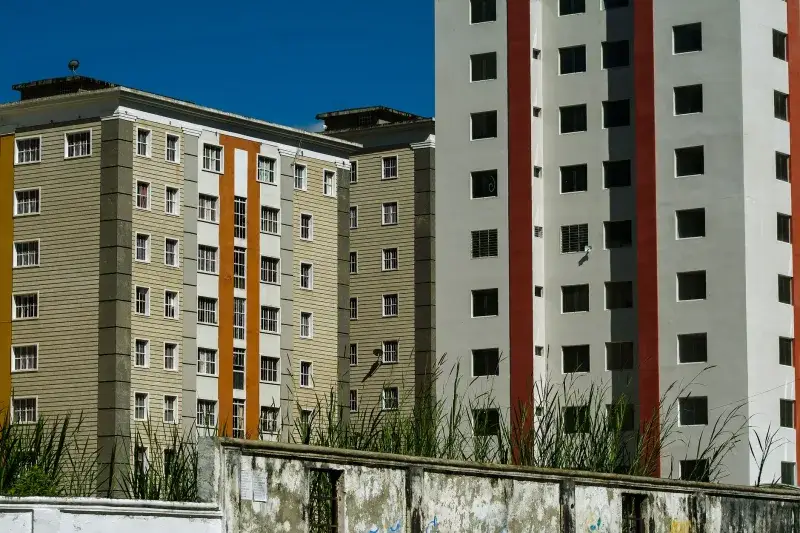 Modern apartment buildings with colorful facades against a clear blue sky in Venezuela.
