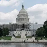 US Capitol with dome, statue, and reflecting pool on a sunny day in Washington, D.C.