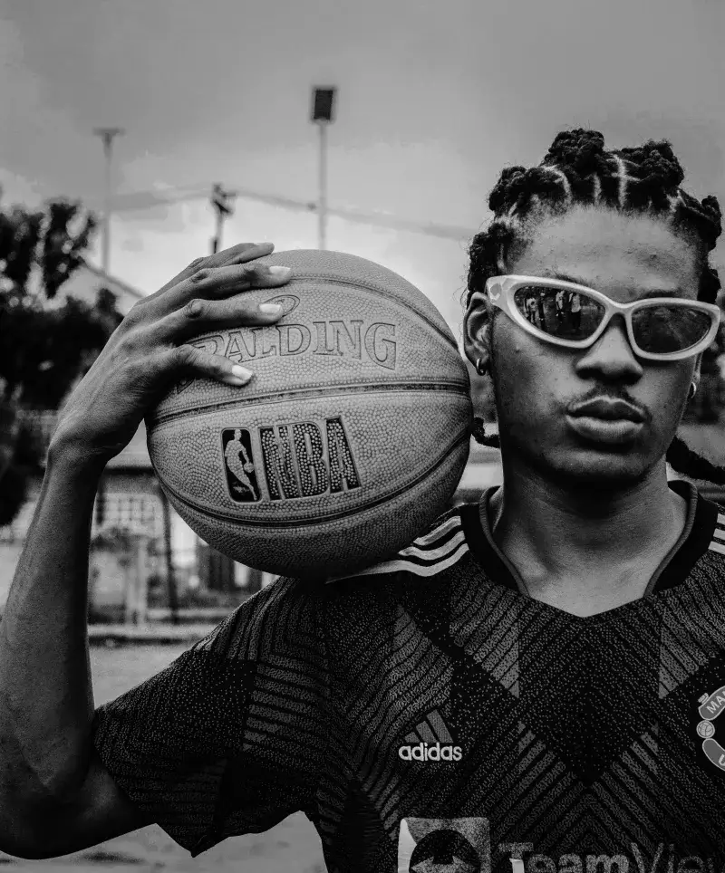 Black and white portrait of a young basketball player holding an NBA ball.
