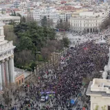 Aerial view of a large demonstration at Plaza de Cibeles, Madrid, Spain, showcasing urban architecture and civic engagement.
