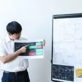 Businessman presents cryptocurrency analysis with graphs and charts on a whiteboard.