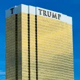 A striking view of Trump Tower in Las Vegas with its golden facade against a blue sky.