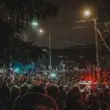 Crowd gathers peacefully at night protest in Lithuania streets.