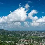 Breathtaking aerial view of Port of Spain with lush hills and clear skies, showcasing Trinidad's vibrant cityscape.