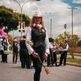 Vibrant parade featuring performers in costume on the streets of Mérida, Venezuela.