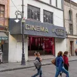 Street view showcasing Cinema Rio and local shops in Mexico City's bustling area.