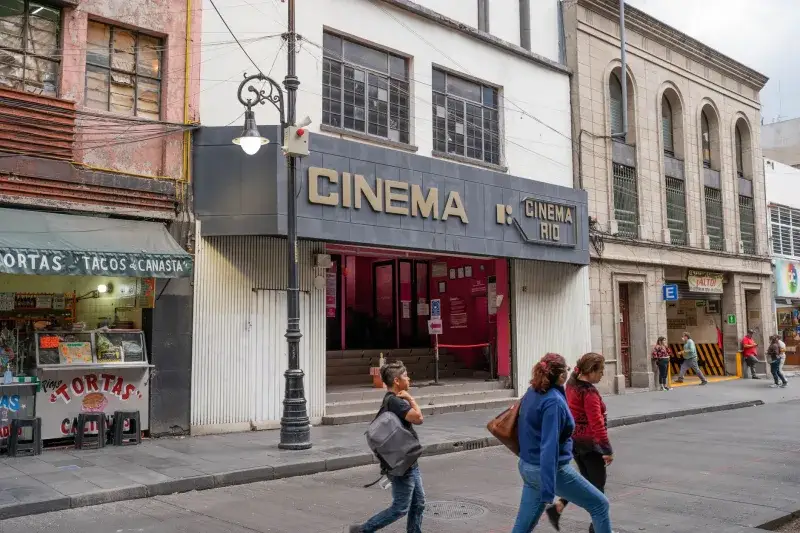 Street view showcasing Cinema Rio and local shops in Mexico City's bustling area.