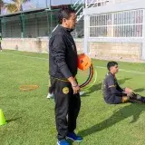 A soccer coach instructs young players on a sunny day at a training field in Texcoco, Mexico.
