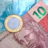 A close up of a money bill with a coin on top of it