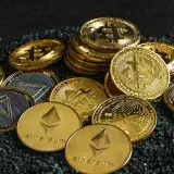 A group of gold cryptocurrency coins on top of black stones