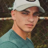 Close-up portrait of a young man wearing a cap, outdoors in Táchira, Venezuela.