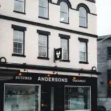 Elegant facade of Anderson's butcher shop with snow-covered entrance on a winter day.