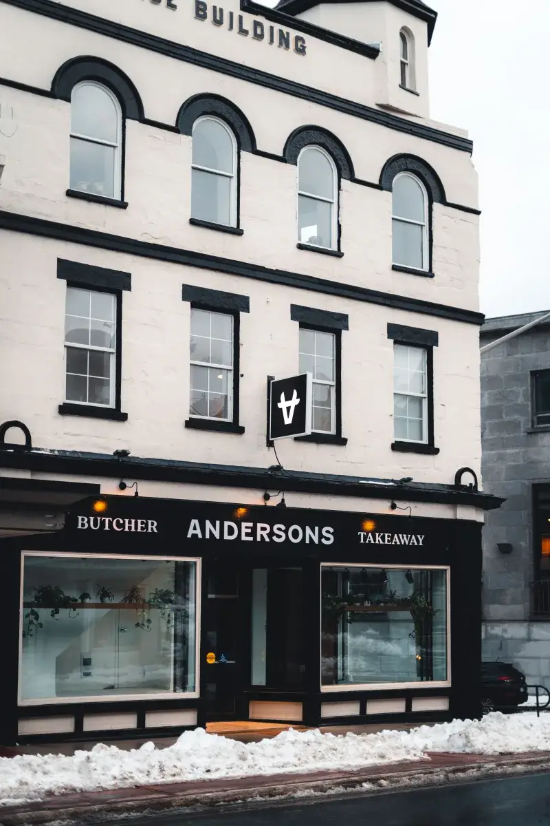 Elegant facade of Anderson's butcher shop with snow-covered entrance on a winter day.