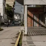 Street scene in Mérida, Venezuela with vehicles and brick structures, capturing urban life.