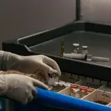 Gloved hands organizing vials in a medical setting, emphasizing precision and hygiene.
