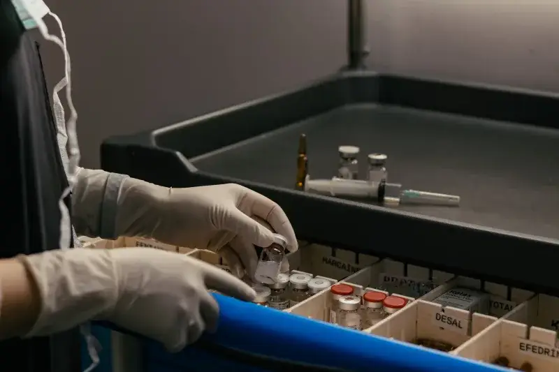 Gloved hands organizing vials in a medical setting, emphasizing precision and hygiene.