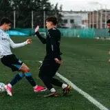 High-energy soccer training with young athletes practicing on a field outdoors.