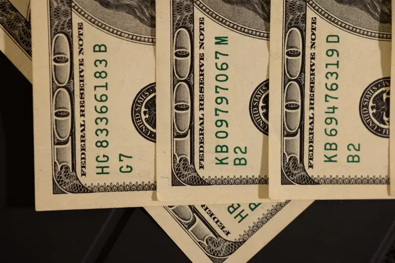 Detailed close-up shot of US dollar bills displaying serial numbers and Federal Reserve details.