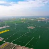 Expansive aerial view of wind turbines across farmland in Jiujiang, China, highlighting sustainable energy.