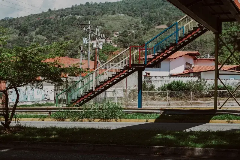 Colorful pedestrian overpass in Mérida, Venezuela surrounded by lush greenery.