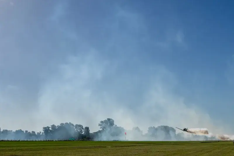 Dynamic stunt plane performing aerial acrobatics over a field in General Rodríguez, Argentina.