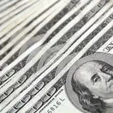 Detailed image showing a close-up of neatly stacked US dollar bills, ideal for financial and economic themes.