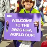 A person holds a sign welcoming the 2026 FIFA World Cup in Seattle.