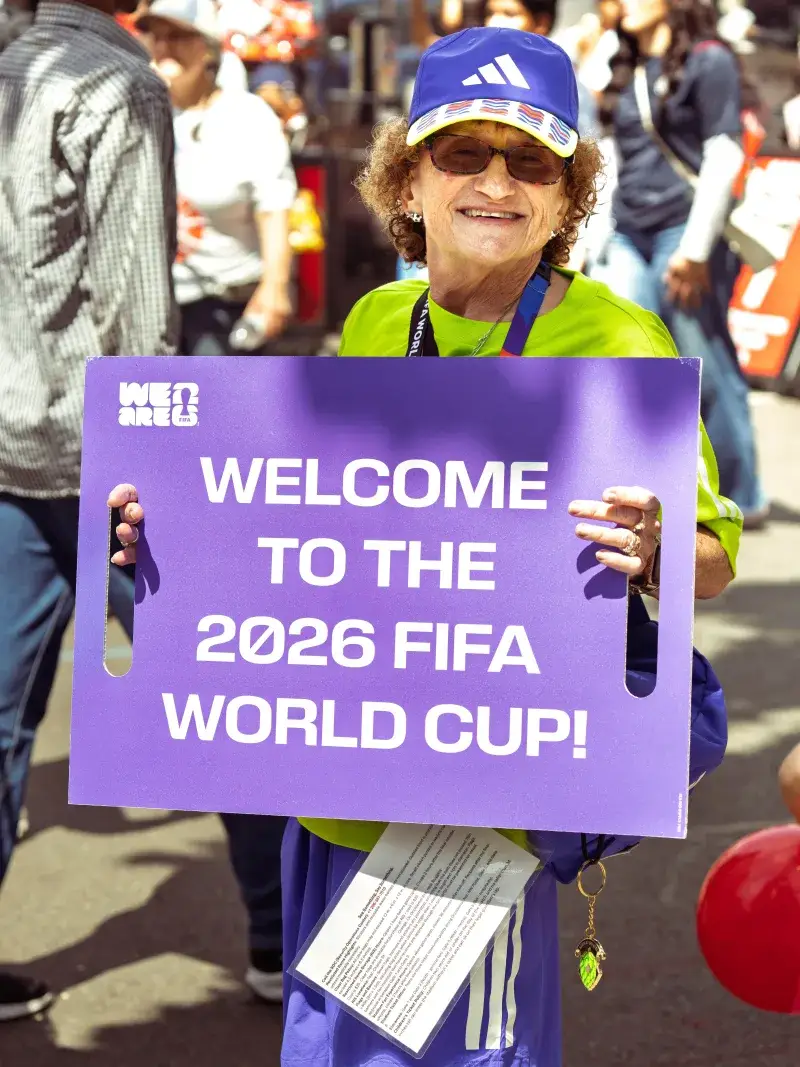 A person holds a sign welcoming the 2026 FIFA World Cup in Seattle.