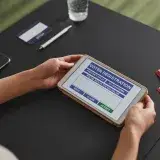 A person using a tablet for voter registration, highlighting digital voting processes.