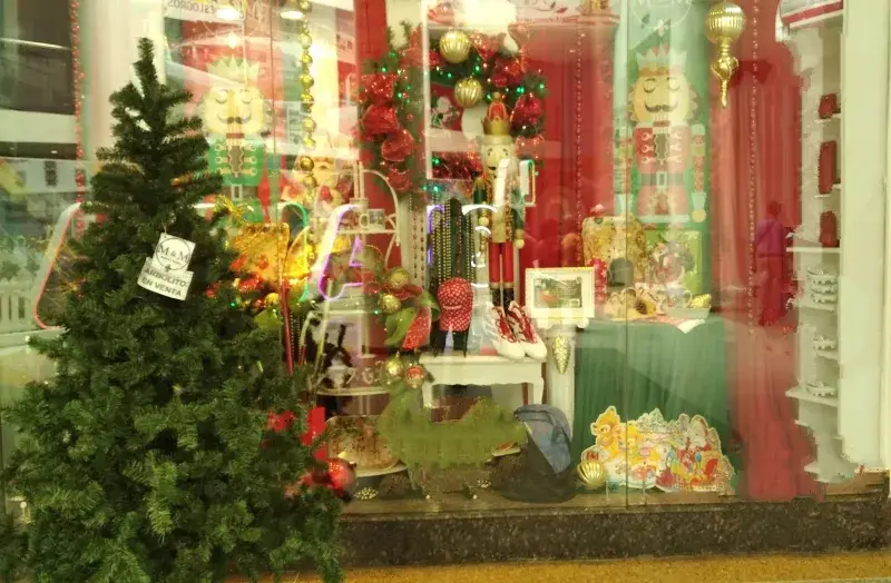 Vibrant display window featuring Christmas decorations and a tree in Catia La Mar, Venezuela.