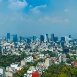 A panoramic view of Mexico City's skyline with skyscrapers and blue sky.