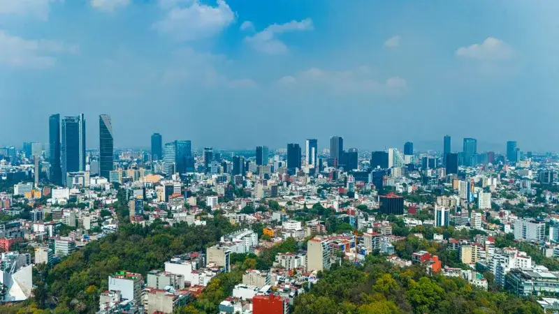 A panoramic view of Mexico City's skyline with skyscrapers and blue sky.