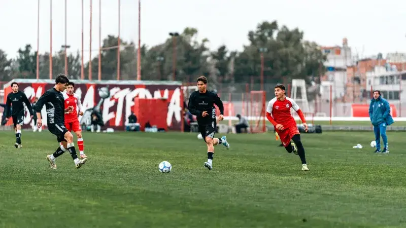 Players in motion during a competitive outdoor soccer match on a grassy field.