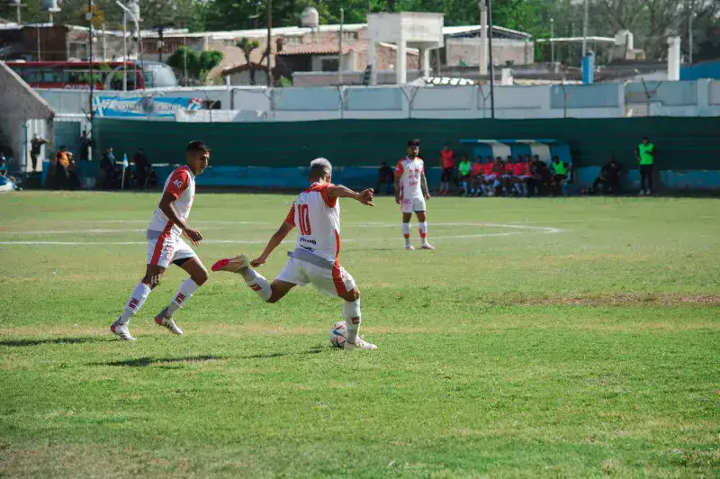 Intense soccer game in Mina, Mendoza, Argentina showcasing teamwork and action on a sunny day.