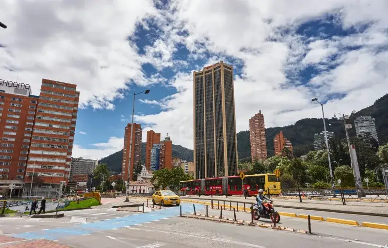 Explore the bustling streets of Bogotá, Colombia, featuring skyscrapers, TransMilenio bus, and lively urban scenery.