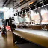 Contemporary Starbucks Reserve coffeeshop interior featuring a sleek espresso machine with a reflective surface.