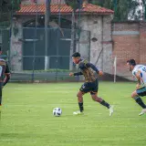 Dynamic action shot of soccer players competing on a grassy field in Texcoco, México.
