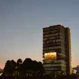 View of the UNAM Rector Tower in Mexico City at sunset, showcasing urban architecture and evening ambiance.
