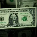 Detailed shot of a US dollar bill on a reflective surface, highlighting currency design.