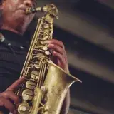 Close-up of a jazz musician performing with a saxophone, showcasing musical artistry.